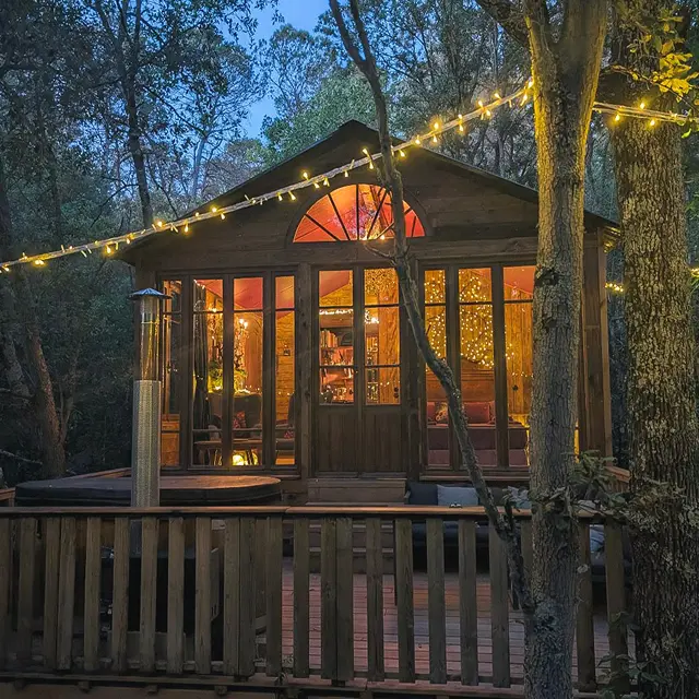 Cabane en bois éclairée en pleine forêt
